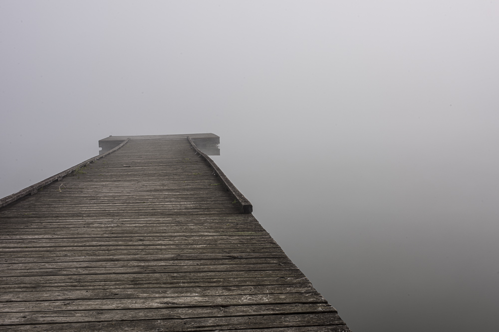 A dock in the fog on a quiet Fall morning.