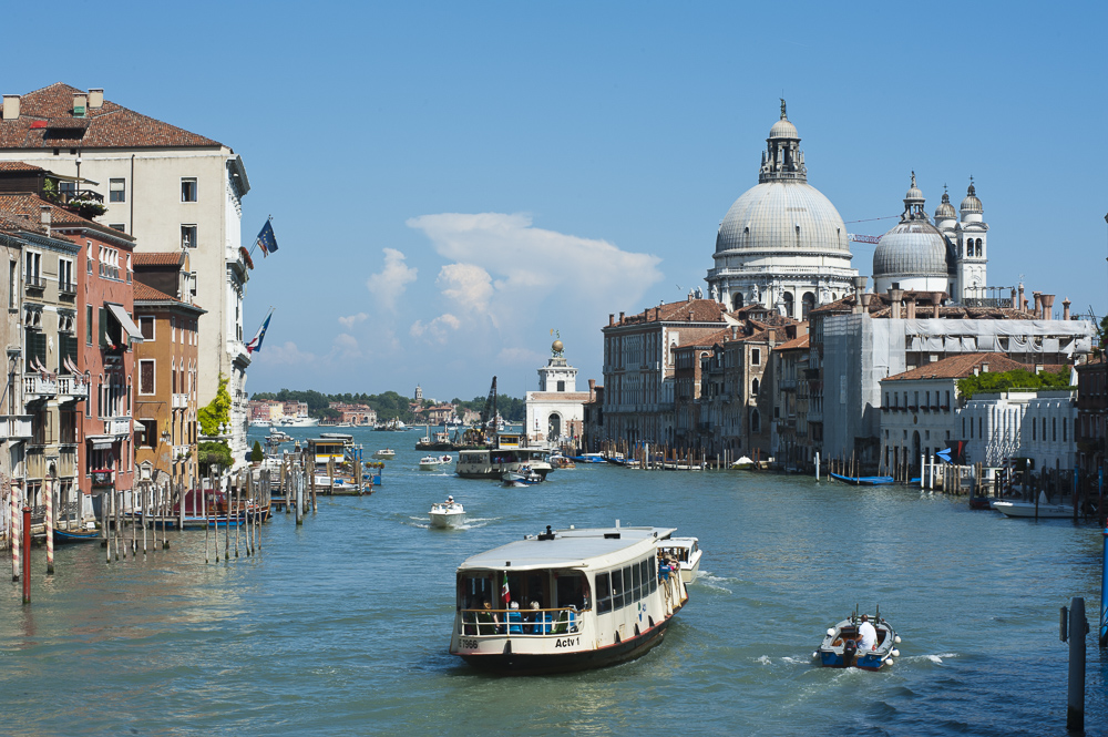 Vaporatto (buses) on the Grand Canal, basillica Santa Maria Della Salute in the background, Venice, Italy