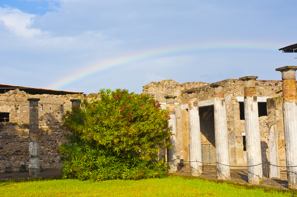 A rainbow over ruins and flowering trees, Pompei, Italy