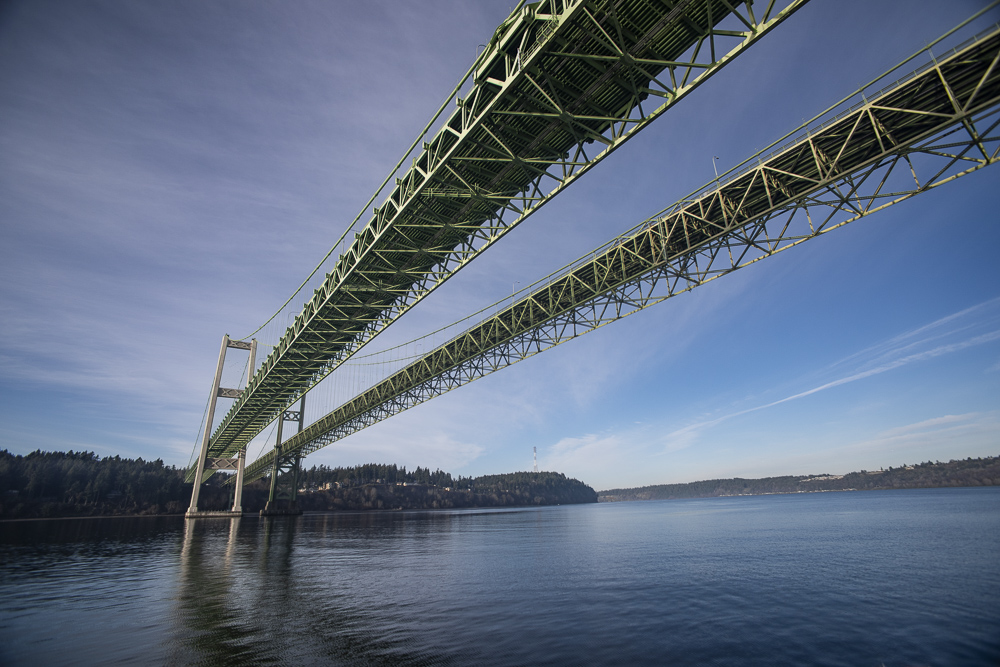 The Tacoma Narrows Bridges from the water surface. looking North West toward Point Evans.  The Bridges stretch over a portion of the Puget Sound and connects Tacoma to the Olympic Peninsula, Washington.