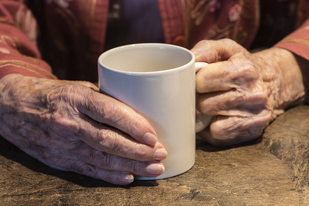 Senior Woman's hands holding a coffee cup.
