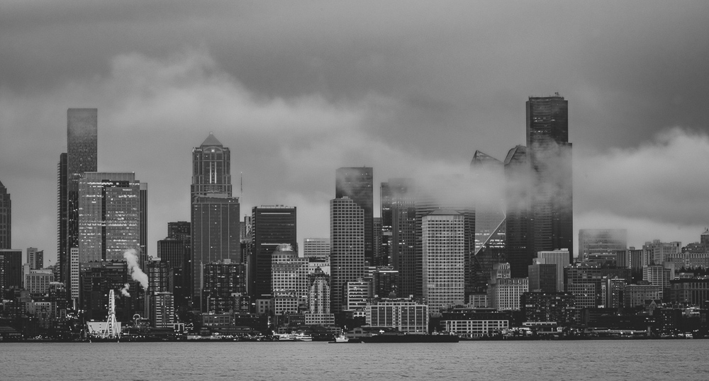 Seattle, Washington skyline from West Seattle across Elliott Bay on a rainy afternoon with wisps of low clouds and fog drifting through the tall buildings